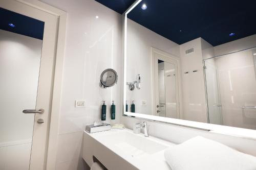 a bathroom with a sink and a mirror at Hilton Sorrento Palace in Sorrento