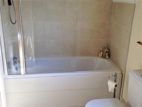 a bathroom with a white tub and a toilet at Stunning Detached 3 Bedroom House Islandandmagee in Larne