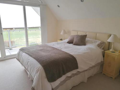 a bedroom with a bed and a large window at Stunning Detached 3 Bedroom House Islandandmagee in Larne