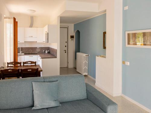 sala de estar con sofá azul y cocina en La Betulla - appartamento indipendente con vista, en Ballabio