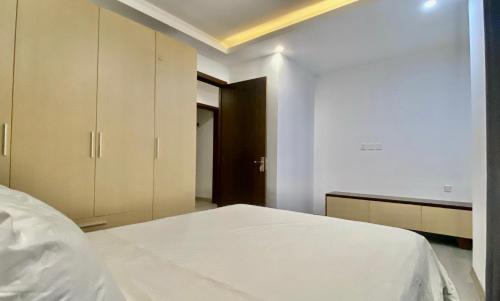 1 dormitorio con 1 cama blanca y armario en Wins Apartment, en Hanói