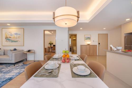 a dining room and living room with a table and chairs at Somerset Valero Makati in Manila