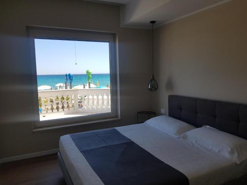 a bedroom with a large window with a view of the beach at Blu Sea apartments in Pietra Ligure