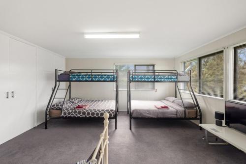 two bunk beds in a room with a tv at Quiet Holiday Home in Surf Beach VIC in Surf Beach