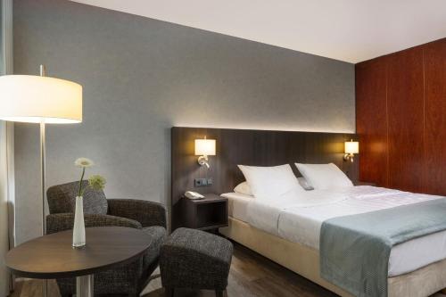 a hotel room with a bed and a table and chairs at Maritim Hotel Bremen in Bremen