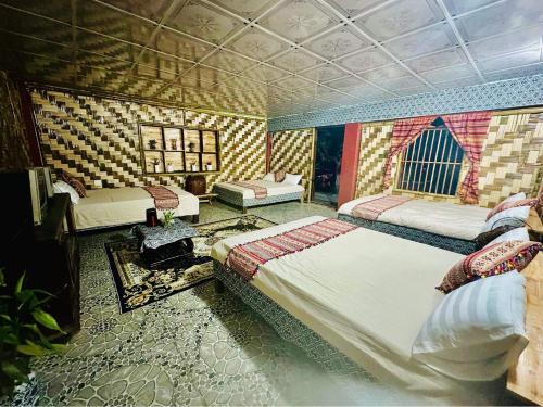 een slaapkamer met 2 bedden in een kamer met patronen bij Homestay Minh Ngọc in Ban Hin Lom