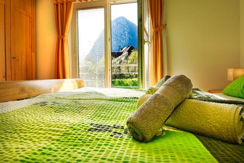 een slaapkamer met een groen bed en een groot raam bij Apartments Pr' Pavleto in Bohinj