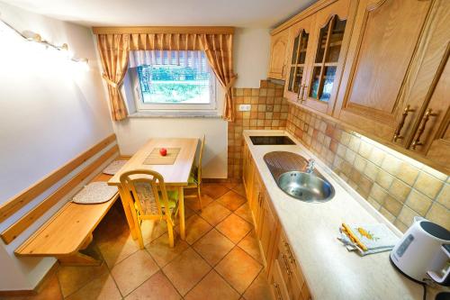 een kleine keuken met een tafel en een wastafel bij Apartments Pr' Pavleto in Bohinj