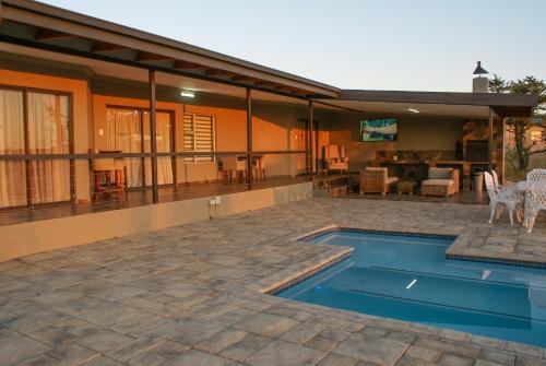 een huis met een zwembad en een patio bij Casa de la Presa 2 in Polokwane