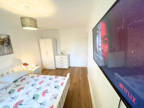 a bedroom with a large screen tv and a bed at Amazing Double Room In Greenwich Area in London