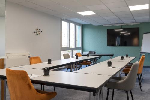 a classroom with tables and chairs and a chalkboard at PoMo Hôtel & Restaurant in Échirolles