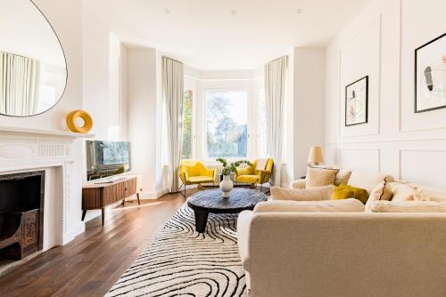Beautiful large luxury home in London في سيدكوب: غرفة معيشة مع أريكة ومدفأة