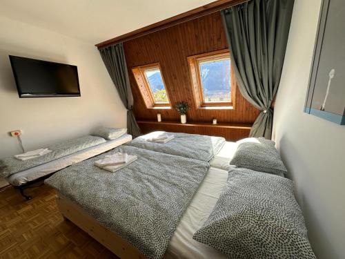 a bedroom with two beds and a flat screen tv at App Bovec in Bovec
