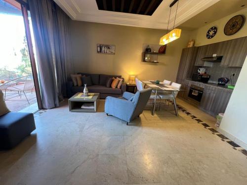 un soggiorno con divano e tavolo di Appartement avec Solarium Privé au Vizir Résidence Prestigieuse avec Accès au Parc a Marrakech