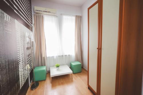 a room with green chairs and a table and a window at AMMOTTI Hotel in Ohrid
