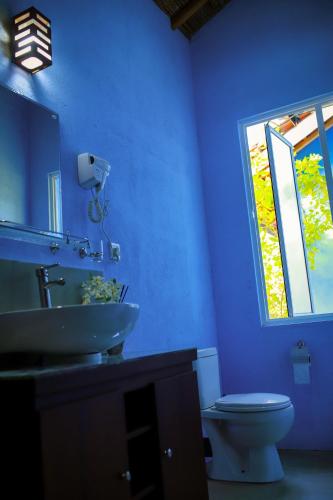 a bathroom with a sink and a toilet and a window at Nayan's Paradise in Kottanitivu