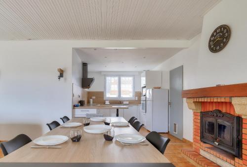 une salle à manger avec une grande table et une cheminée dans l'établissement Évasion en famille à Brem-sur-Mer, à Brem-sur-Mer