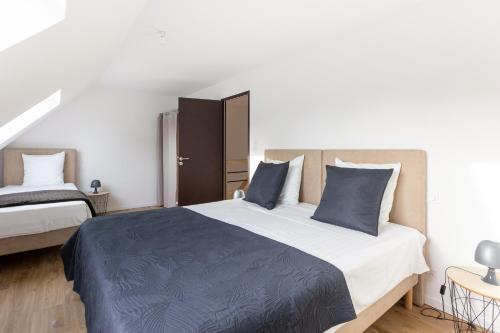 - une chambre avec un grand lit et des oreillers bleus dans l'établissement Gîtes de la Mer - 4 Maisons avec piscine partagée, à Erquy