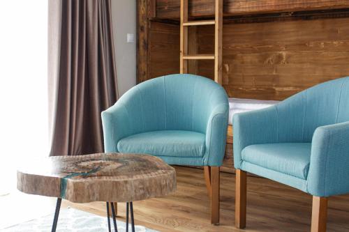 two blue chairs and a coffee table in a room at Pensiunea Banffy in Topliţa