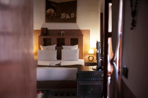 a bedroom with a bed with white pillows at Riad Alili in Marrakech