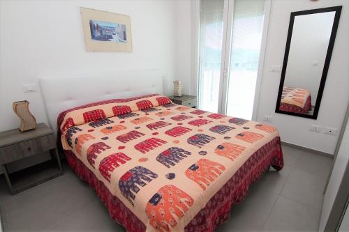 a bedroom with a bed with a quilt on it at Appartamento Raffaello in San Benedetto del Tronto