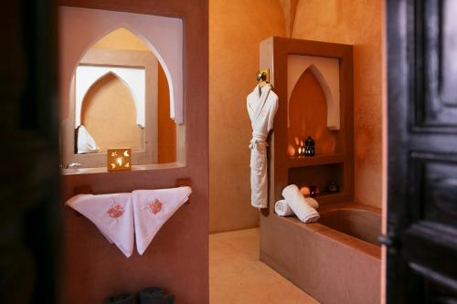 a bathroom with a mannequin standing in a mirror at Riad Alili in Marrakech