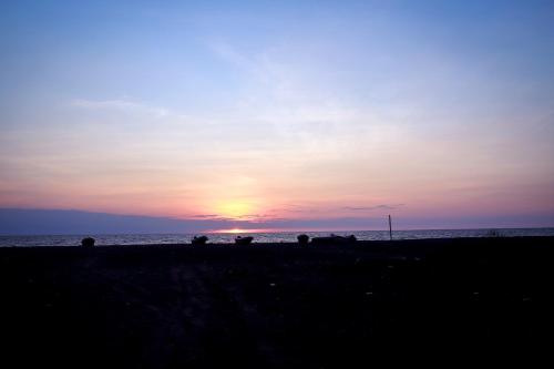 a group of people on the beach at sunset at Nayan's Paradise in Kottanitivu