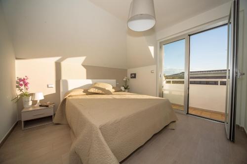a bedroom with a bed and a large window at Palazzina Cala Luna Suite in San Benedetto del Tronto