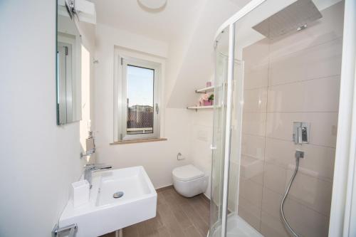 a white bathroom with a sink and a toilet at Palazzina Cala Luna Suite in San Benedetto del Tronto