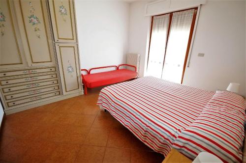 a bedroom with a bed and a red chair at Palazzina Magnolia in San Benedetto del Tronto