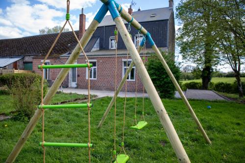 a playground with a bunch of swings in a yard at La Villa Beausejour in Baives