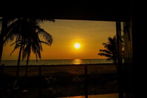 a sunset seen from a window of a beach at Nayan's Paradise in Kottanitivu