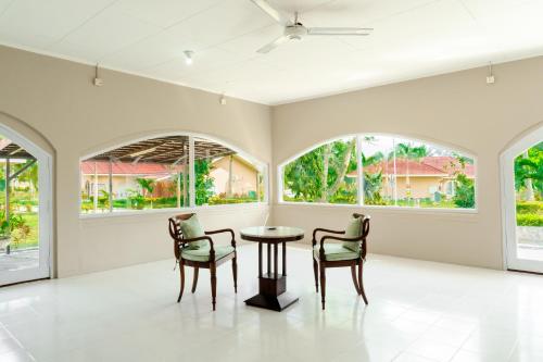 Habitación con 2 sillas, mesa y 2 ventanas en LA CASA BORNEO, en Bentakan Kecil