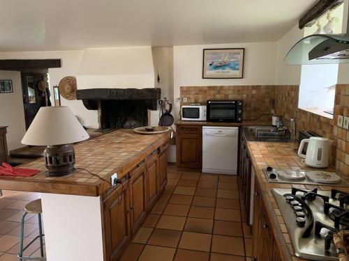 - une cuisine avec un comptoir et une cuisinière four supérieur dans l'établissement Longère familiale - SAINT POTAN, à Saint-Potan