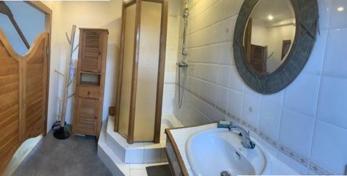 une salle de bain avec un lavabo, un miroir et une baignoire dans l'établissement Longère familiale - SAINT POTAN, à Saint-Potan