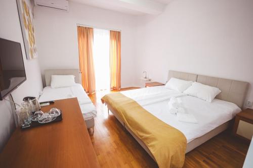 a hotel room with two beds and a television at AMMOTTI Hotel in Ohrid
