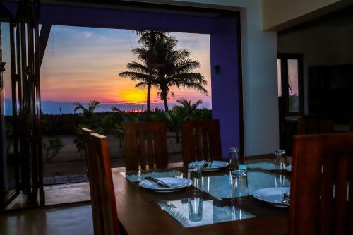 a dining room table with a view of the sunset at Nayan's Paradise in Kottanitivu