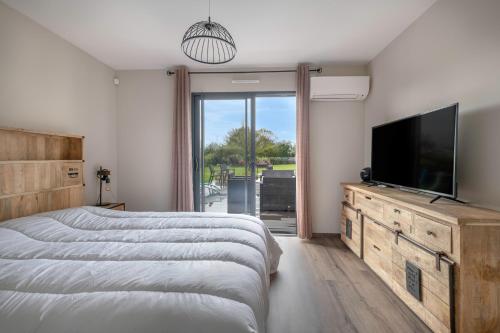 une chambre avec un lit et une télévision à écran plat dans l'établissement Maison familiale avec jacuzzi à Pornic, à Pornic