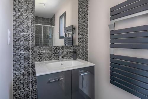 une salle de bain avec un lavabo et un miroir dans l'établissement Maison familiale avec jacuzzi à Pornic, à Pornic