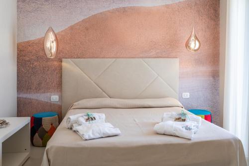 una camera da letto con un letto e asciugamani di Le Gemelle Boutique Hotel a Torre Suda