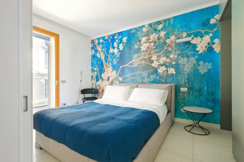 una camera con un letto con una parete blu di Luxury Apartment con Terrazza, Palestra, CoWork & Box Privato a Milano