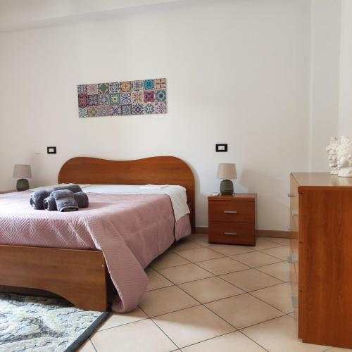 een slaapkamer met een bed en een tafel bij La casa di Andrea in Terrasini