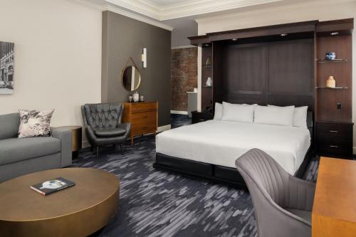 a hotel room with a bed and a couch and a table at Courtyard Tacoma Downtown in Tacoma