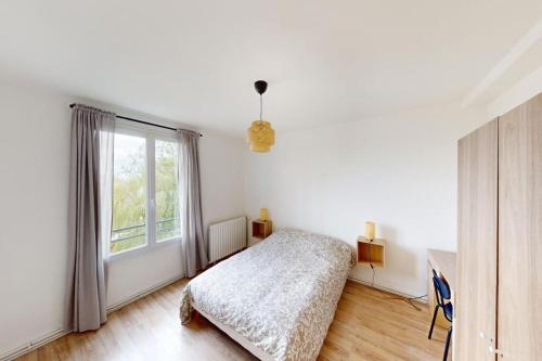 une chambre avec un lit et une grande fenêtre dans l'établissement Appartement 3 chambres Coty, au Havre