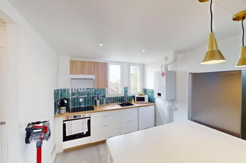 - une cuisine blanche avec un lit dans une chambre dans l'établissement Appartement 3 chambres Coty, au Havre