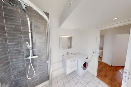 une salle de bain avec douche et machine à laver dans l'établissement Appartement 3 chambres Coty, au Havre