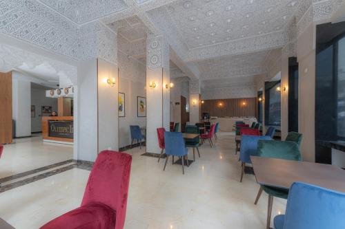 een eetkamer met stoelen en tafels en een plafond bij Olympic Inn Casablanca in Casablanca