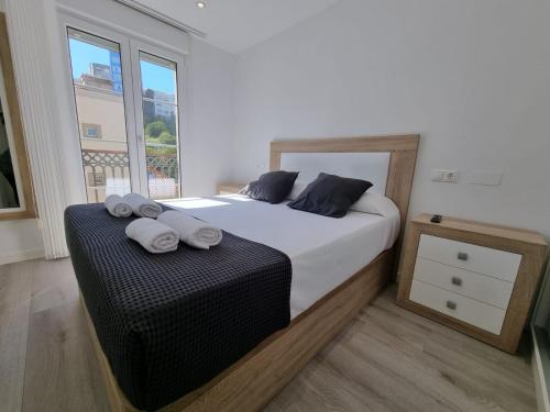 a bedroom with a large bed with towels on it at VibesMalpica - Canido 12 in Malpica