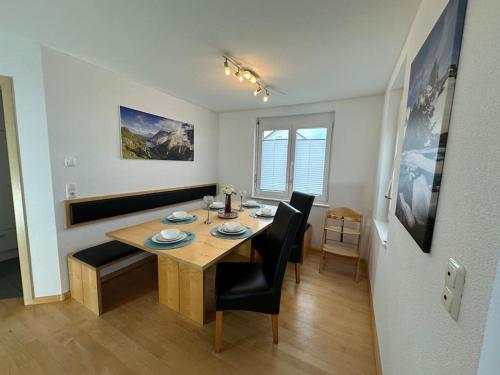 ein Esszimmer mit einem Holztisch und Stühlen in der Unterkunft Ferienwohnung Bodenseeblick in Hagnau