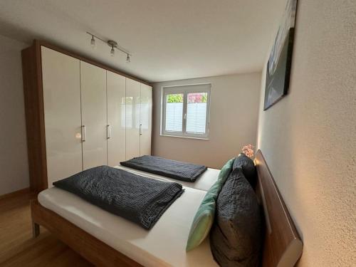 een slaapkamer met 2 bedden en een raam bij Ferienwohnung Bodenseeblick in Hagnau